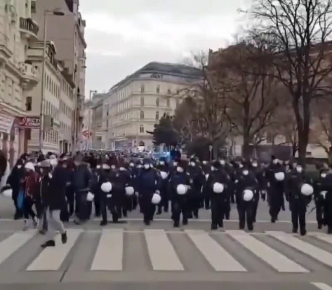 Police in Vienna walk with their helmets in hand in solidarity with anti lockdown protesters this weekend.