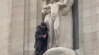 SOMEONE HAS CLIMBED ONTO THE BBC BUILDING AND SMASHING UP THE ERIC GILL PEDO STATUE